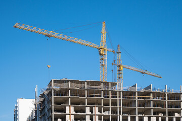 Construction cranes on the background of the sky. Building the skyscraper.