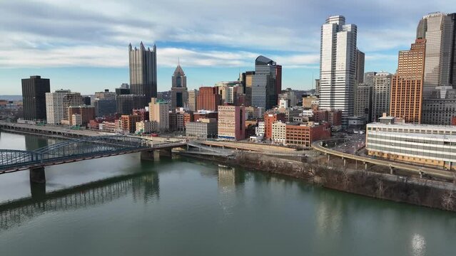 Pittsburgh skyline during golden hour on beautiful day. Aerial establishing shot over Monongahela River.