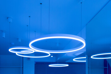 Ceiling with round modern LED lamps. Suspended fluorescent lights under the ceiling. Careful energy...
