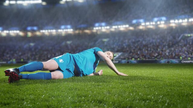 Aesthetic Shot of Blue Team Soccer Football Player Sliding on The Grass, Successfully Tackling the Opponent on Stadium With Croud Cheering. Super Slow Motion Captures Dangerous Sports Moment.