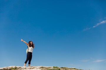 woman looking up at the big blue sky travel hiking