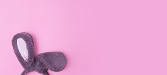 Top view of fluffy bunny rabbit ears on pink background.Easter minimal concept.Large banner with negative space.
