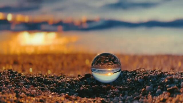 Crystal ball on the Apricot Crush seashore. Sunset on the beach.