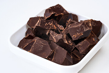 Pieces of broken chocolate highlighted on a white background as packaging design elements.