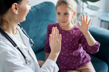 Doctor and kid patient giving Five to each other at home. Child patient at usual medical inspection. Medicine, healthcare concepts.