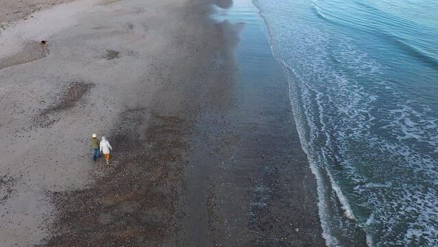 Aerial view of Little Compton beach, couple with dog having an afternoon walk