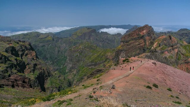 Aerial view over the clouds from slopes of Pico do Arieiro, Madeira, Portugal timelapse. Overview above the fog. Tourists walking on a footpath