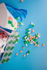 Shopping cart and pills in blisters and plastic container for medicines. Concept of buying medicine online, delivery of medical devices.