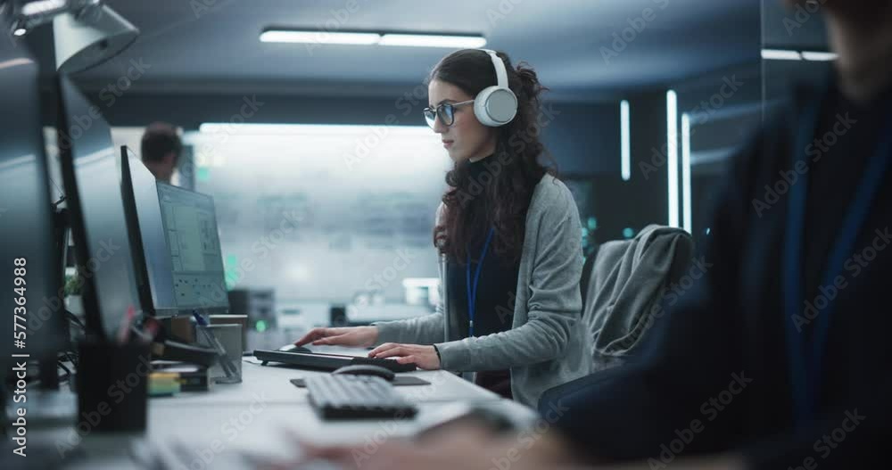 Poster switching focus from close up hands to a young female engineer working on computer in a technologica