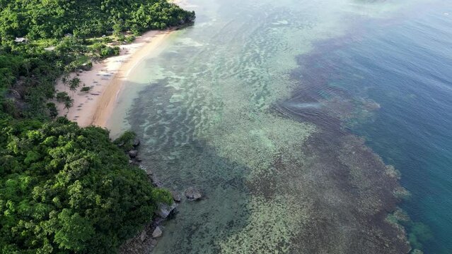 Amazing Aerial view of Coastal Reef under transparent Sea Waves next to white sand beach in Catanduanes, Philippines.