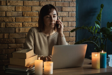 Young woman using laptop to work at home during electricity outage. Remote work at home concept....