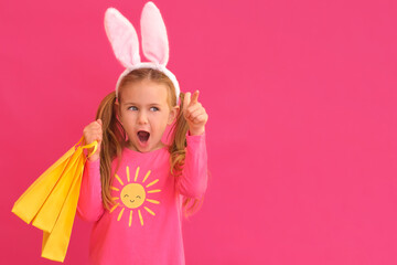Easter shopping. Excited emotion surprise adorable child girl in bunny ears rabbit costume hold...