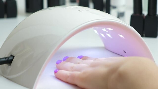 Drying the top for gel polish in an ultraviolet LED lamp. Manicure at home yourself, beauty salon