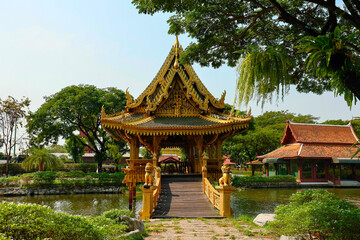 Chinese architecture of pavilion with corridor bridge in the pond with tree and blue sky background in park at Ancient City,Siam,Samutprakan province, Thailand.
