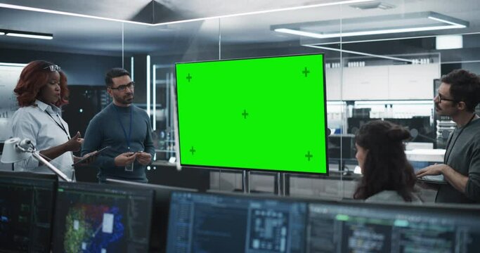 Team of Diverse Software Developers Having a Meeting in a Conference Room with Green Screen Mock Up Display. Manager Making a Presentation for Project Managers at the Office
