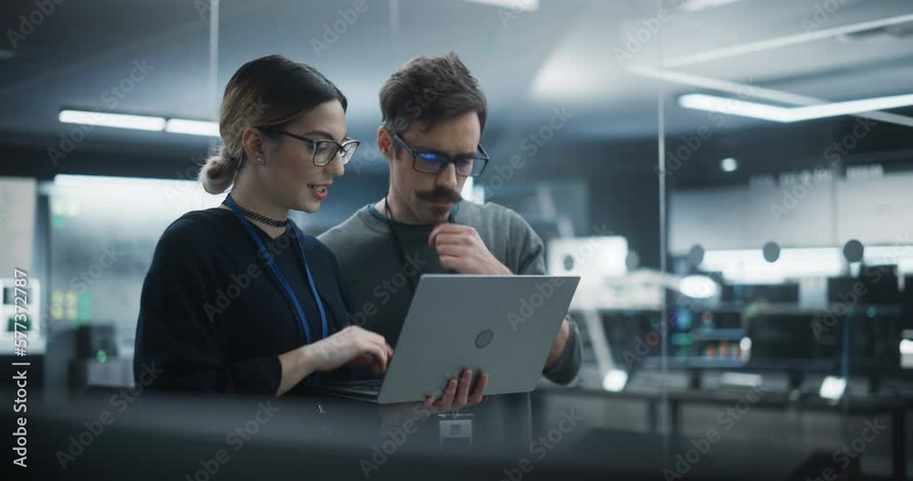 Aufkleber Portrait of Two Creative Young Female and Male Engineers Using Laptop Computer to Analyze and Discuss How to Proceed with the Artificial Intelligence Software. Standing in High Tech Research Office