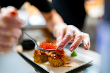 professional chef's hands making sushi and rolls in a restaurant kitchen