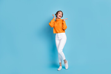 Fototapeta na wymiar Full body photo of attractive young woman astonished hands look empty space wear trendy orange garment isolated on blue color background