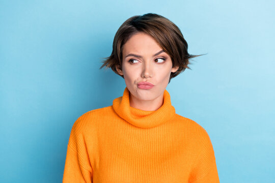 Photo portrait of attractive young woman look skeptical empty space eyebrow dressed stylish orange outfit isolated on blue color background
