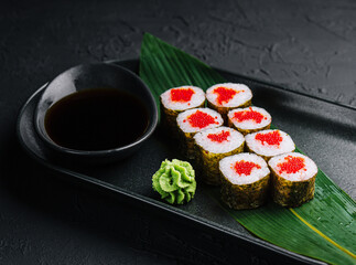 Maki Sushi with red caviar on black plate