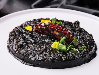 Cooked octopus and black rice in plate