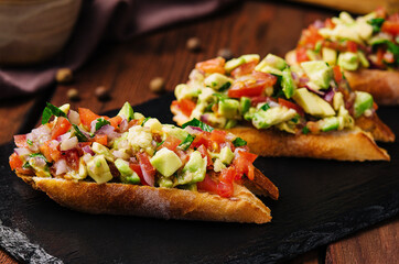 Bruschetta with avocado and tomato closeup