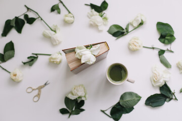 Floral pattern of white flowers and petals, green leaves on a white background. Beautiful elegant luxurious composition with white roses. Top view. Minimal art. Florist, flowers delivery concept