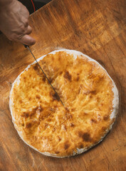 Baked homemade meat pie on wooden background.