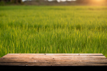 Empty wooden board on table top and blur rice background, mock up for display of goods.