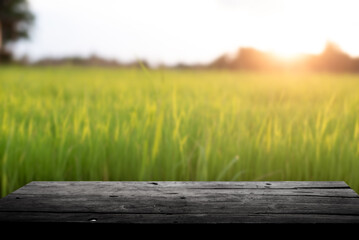 Empty wooden board on table top and blur rice background, mock up for display of goods.