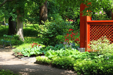 Red pavilion and lush green trees in the park.