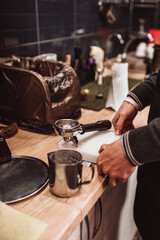 Fototapeta na wymiar Modern equipment in a coffee shop for preparing coffee drinks - a man brews a cappuccino