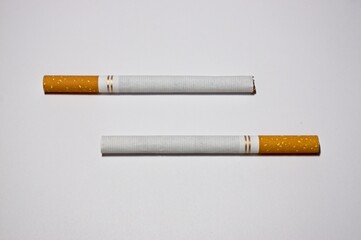 Two cigarettes parallel to each other on white