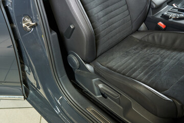 gray car front seat with knobs for adjusting cushion height, angle and lumbar support