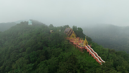 Aerial view at morning mist Wat Phra That Doi Phra Chan. and Daibutsu Buddha on the greenery...