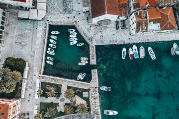 This stunning drone shot offers a bird's-eye view of Hvar's picturesque town nestled against the turquoise waters of the Adriatic Sea. The town's distinctive red rooftops create a beautiful contrast.