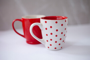 Red and white coffee cup, white cup with dots on the outside and red inside and red cup with white inside