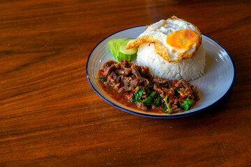 Stir fired chicken with hot basil on top with fried egg, Thai food, kho kra pow, Lunch, Dinner, Popular food in Thailand.