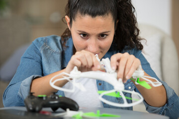 young smiling woman assembling drone propeller at home