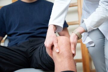 Young doctor neurologist examining her patient. Pretty female orthopedist with patient in her...