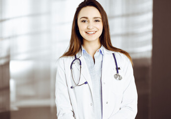 Professional young woman-doctor is looking at camera with a smile. Therapist at work in a clinic's office. Medicine concept.