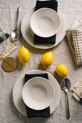 Vintage table setting with Linen napkins and yellow lemons. Decoration table. Close up. Cozy calm meal in the morning in the sunshine.