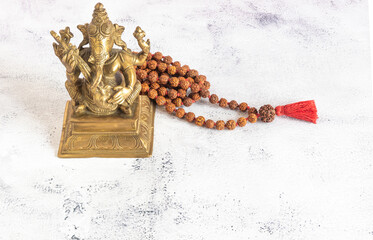 Statue of Ganesh with a rudra  necklace around on a white background with copyspace