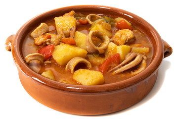A potato stew with calamari, served in a clay bowl, isolated on a white background. Spanish food concept.