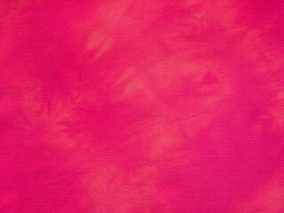 textile background - fabric dyed at home in red with tie-dye stains