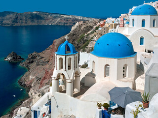 Bell Tower and Blue domed church high on the edge of the volcanic caldera on the Greek island of Santorini (Thira) in the southern Aegean Sea.