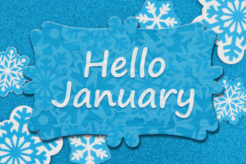Hello January message on wood sign on snowflakes on blue glitter paper