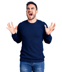 Fototapeta premium Young handsome man wearing casual clothes crazy and mad shouting and yelling with aggressive expression and arms raised. frustration concept.