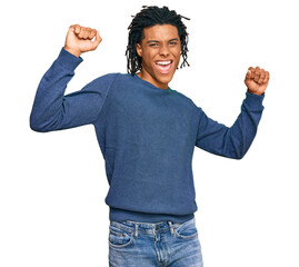 Young african american man wearing casual winter sweater dancing happy and cheerful, smiling moving...