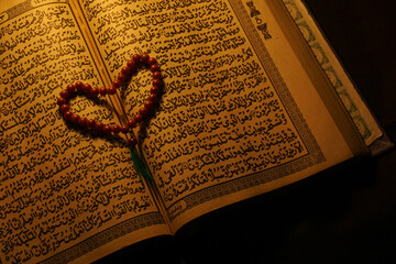 a quran with tasbih form the shape of love